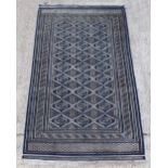 Property of a gentleman - a Bokhara design hand-knotted wool rug with navy ground, 111 by 61ins. (
