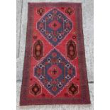Property of a gentleman - an Afghan hand-knotted wool rug with red ground, 74 by 40ins. (188 by