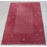 Property of a gentleman - a Turkoman hand-knotted wool rug with red ground, 116 by 80ins. (295 by