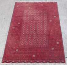 Property of a gentleman - a Turkoman hand-knotted wool rug with red ground, 116 by 80ins. (295 by