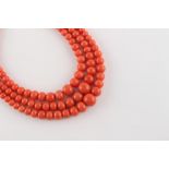 A coral graduated bead three strand necklace, the largest bead (excluding clasp) measuring