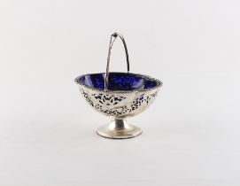 Property of a lady - an Edwardian silver oval quatrefoil sugar basket with swing handle & blue glass