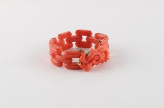 A coral link bracelet with carved bird & snake clasp, with safety chain, approximately 34.4 grams.