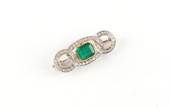 An unmarked white & yellow gold emerald & diamond interlinking loops brooch, the emerald weighing