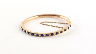 A yellow gold lapis lazuli & seed pearl hinged bangle, approximately 9.1 grams.