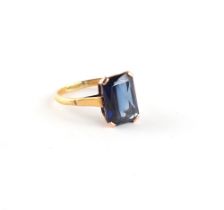A large yellow gold emerald cut synthetic sapphire ring, the stone measuring approximately 14 by