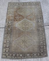 Property of a lady - an antique Caucasian rug, with camel ground, very worn, 106 by 64ins. (270 by