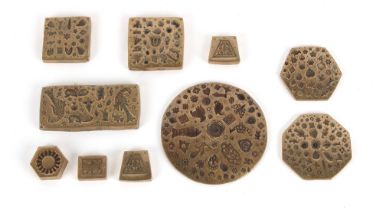 Property of a lady - a collection of ten Kuchi jewellery bronze stamp dies, the largest 4.6ins. (