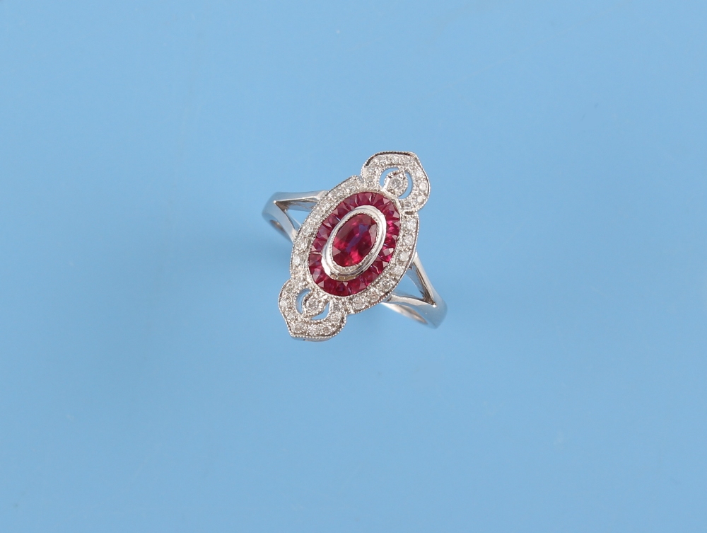 An Art Deco style 18ct white gold ruby & diamond ring, the centre oval cut ruby weighing