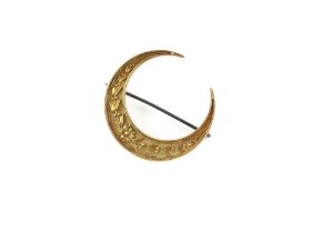 Property of a lady - an unmarked gold (tests 15ct) crescent brooch, the pin steel, approximately