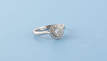 A platinum diamond circular cluster ring, the centre round brilliant cut diamond weighing