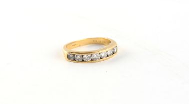 Property of a lady - an 18ct yellow gold ring set with a row of seven round brilliant cut