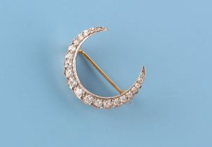 A yellow gold & platinum diamond crescent brooch, approximately 28mm across (excluding pin).