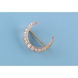A yellow gold & platinum diamond crescent brooch, approximately 28mm across (excluding pin).
