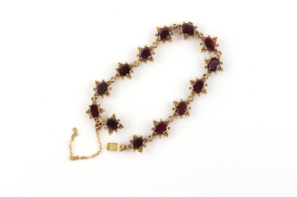 An early 19th century late Georgian yellow gold (tests 18ct) oval cut garnet bracelet, with closed