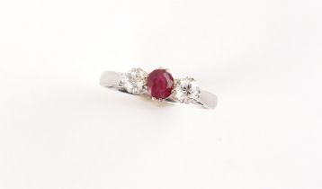 An 18ct white gold ruby & diamond three stone ring, the oval cushion cut ruby weighing approximately