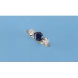 An 18ct yellow gold sapphire & diamond three stone ring, the centre round cut sapphire weighing