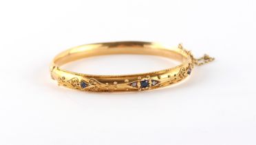 A Victorian yellow gold (tests 15ct) hinged bangle set with sapphires & diamonds, with safety chain,