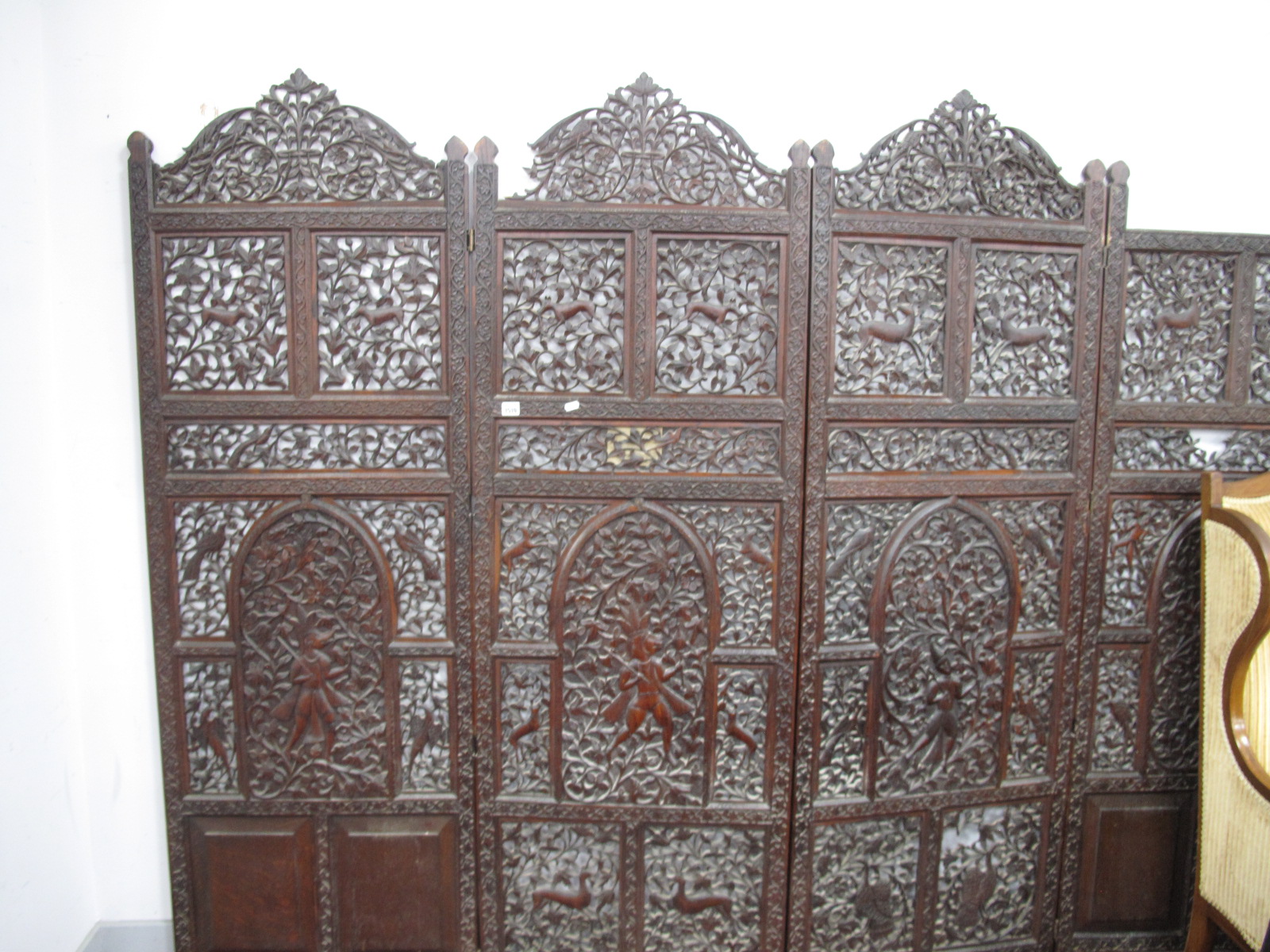 A Late XIX/Early XX Century Indian Hardwood Four Fold Screen, decorated with figures, animals and