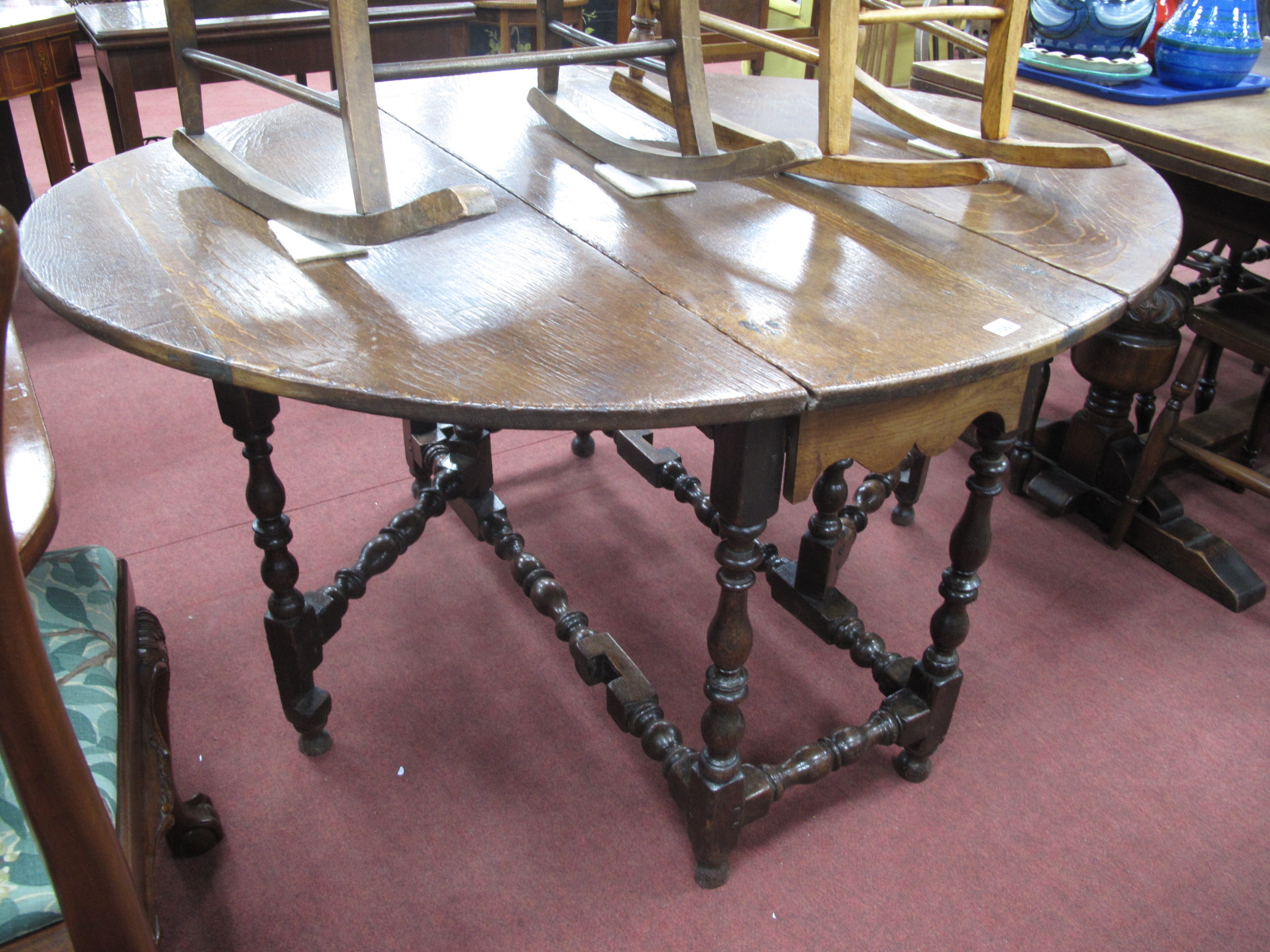 An Early XVIII Century Joined Oak Gate Leg Table, with an oval top, single drawer, on turned and