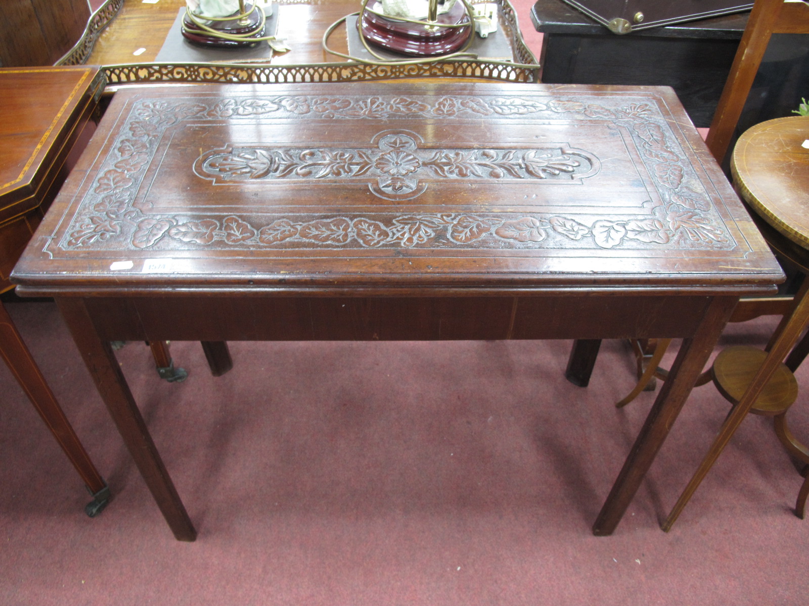 A XVIII Century and Later Mahogany Card Table, with a carved fold over top, on chamfered supports.