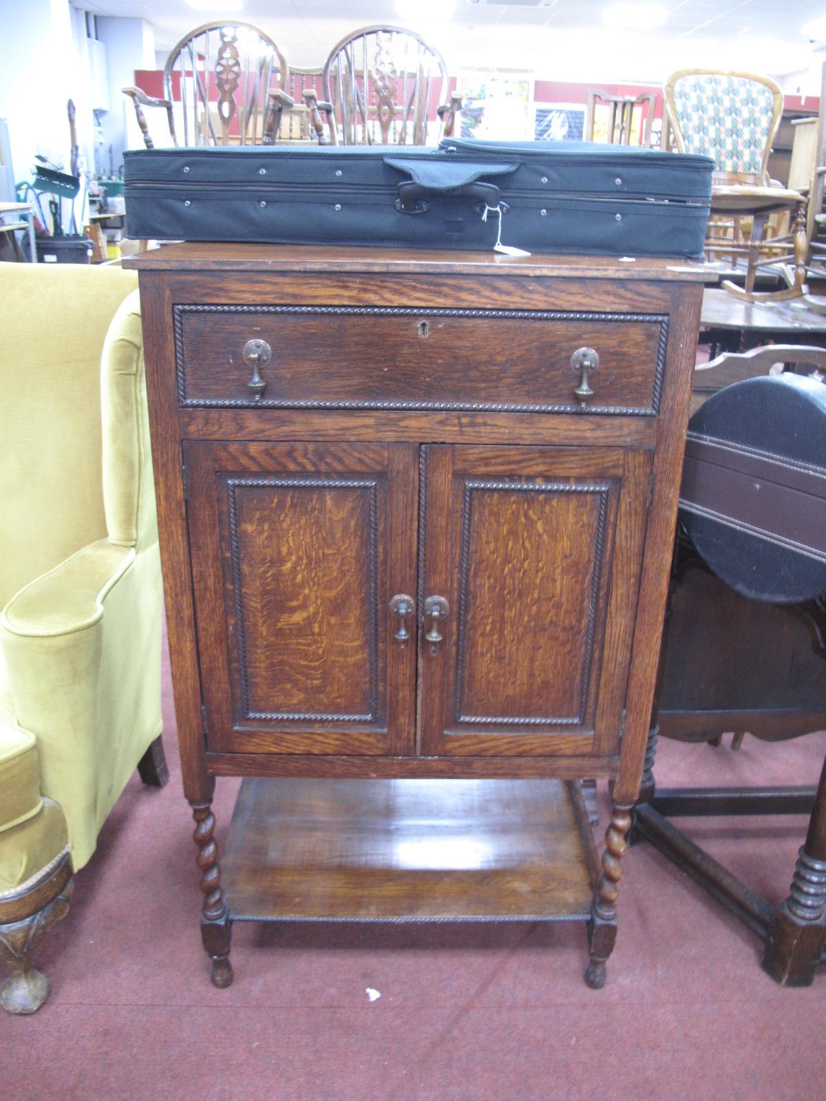 A 1930's Oak Cabinet, with a single drawer, over twin panelled doors, on barley twist and block