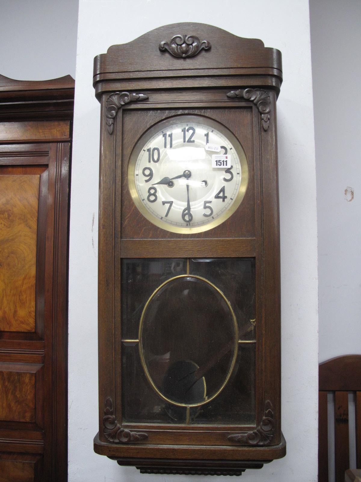 A 1940's Oak Wall Clock, with a silver dial, Arabic numbers, glazed door.