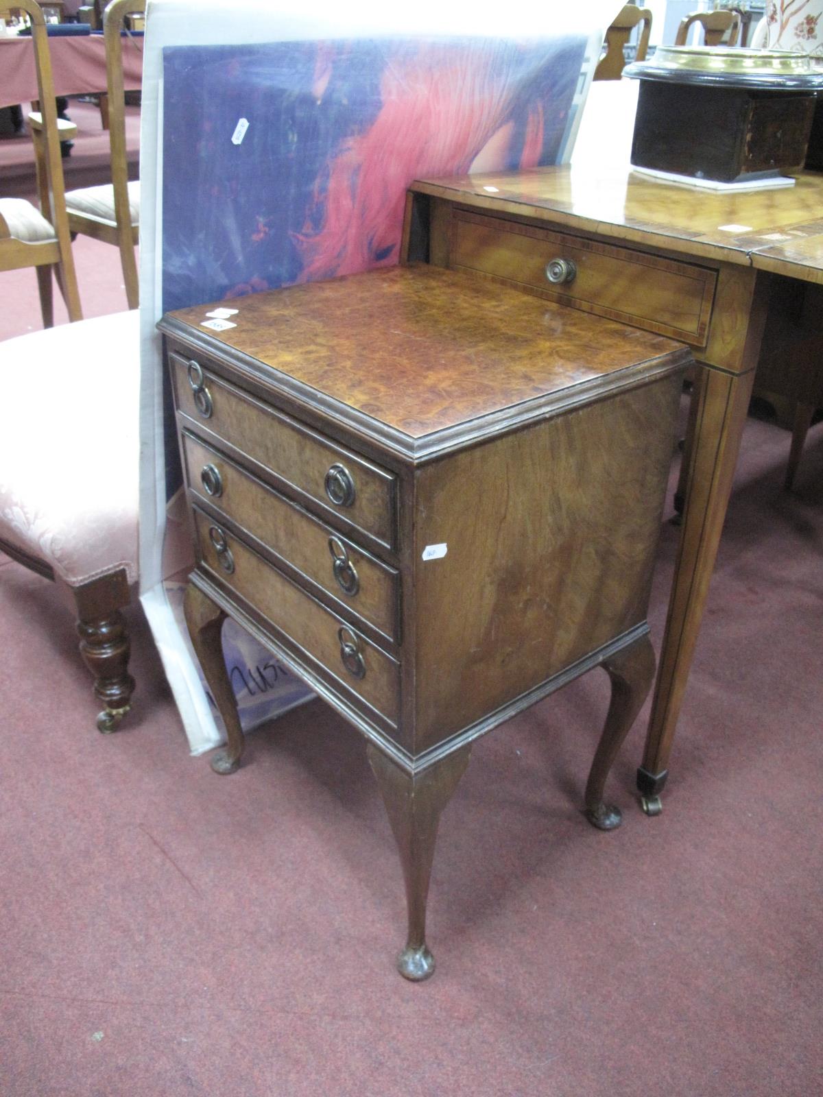 A XX Century Walnut Bedside Chest, with three small drawers, on cabriole legs, pad feet, 42cm wide.