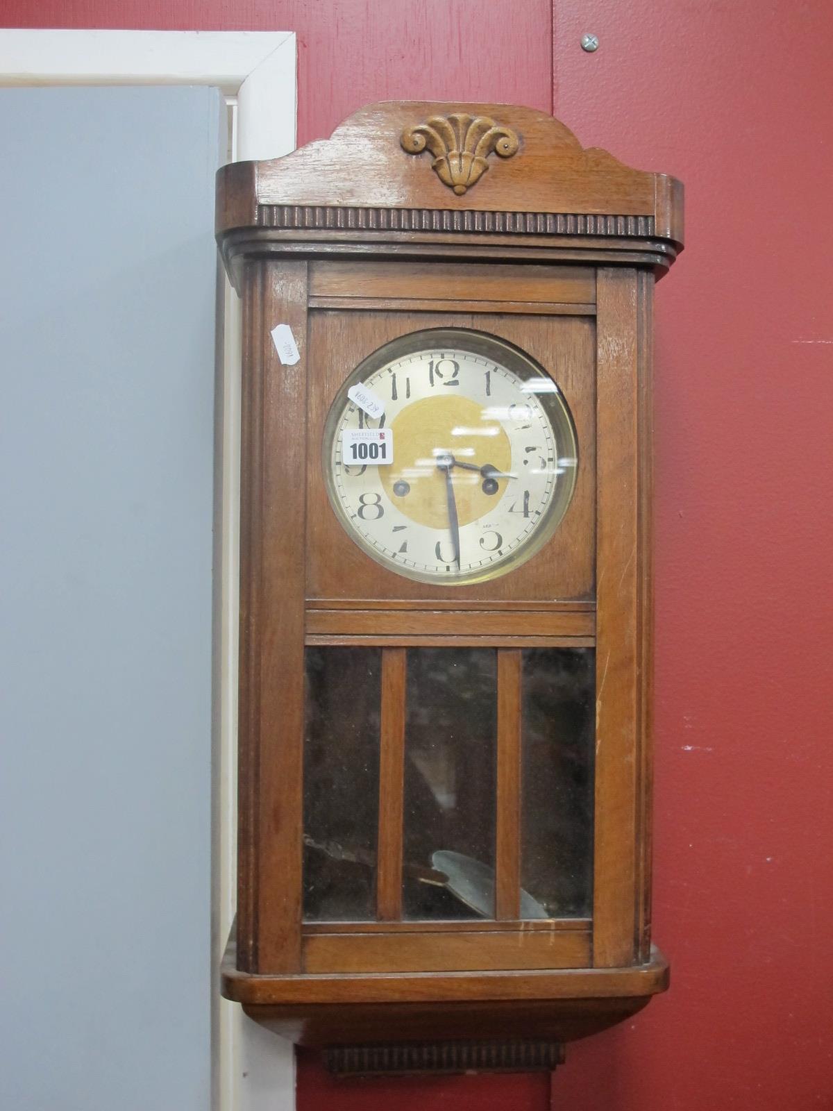 A 1940's Mahogany Wall Clock, with a silver chapter ring, glazed door, 65cm wide.