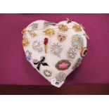 A Collection of Assorted Costume Brooches, in a heart shape cushion.