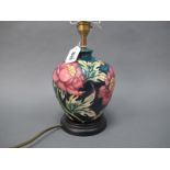 A Moorcroft Pottery Table Lamp, painted in the 'Peony' pattern against a dark blue ground, mounted