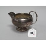 A Hallmarked Silver Jug, Walker & Hall, Sheffield 1935, with bead and reel border (dents) (