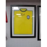 Pele Autograph, black pen signed (unverified) on a yellow Brazil shirt, mounted, glazed and