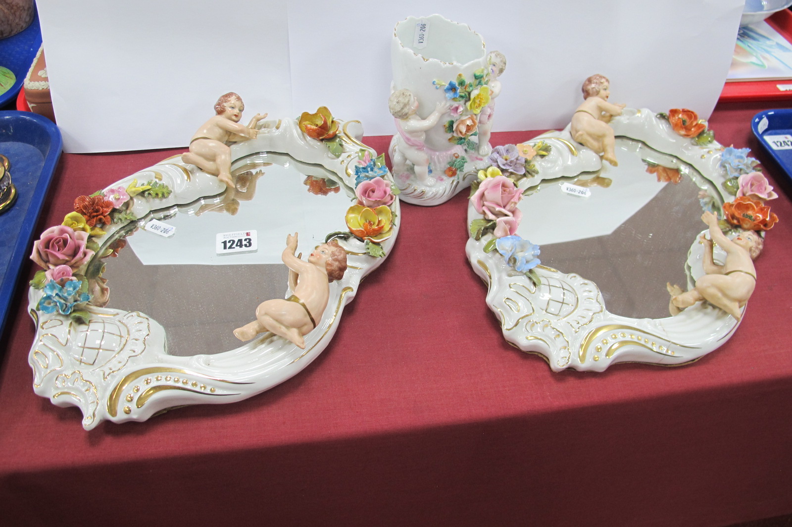 A Pair of Continental Porcelain Wall Mirrors, decorated figures and floral decoration, together with