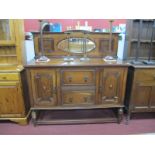 A 1930's Oak Mirror Back Sideboard, with a low arched back, oval mirror two central drawers,
