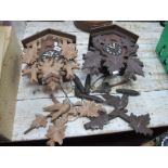 Two German Cuckoo clocks, each with two conifer weights.