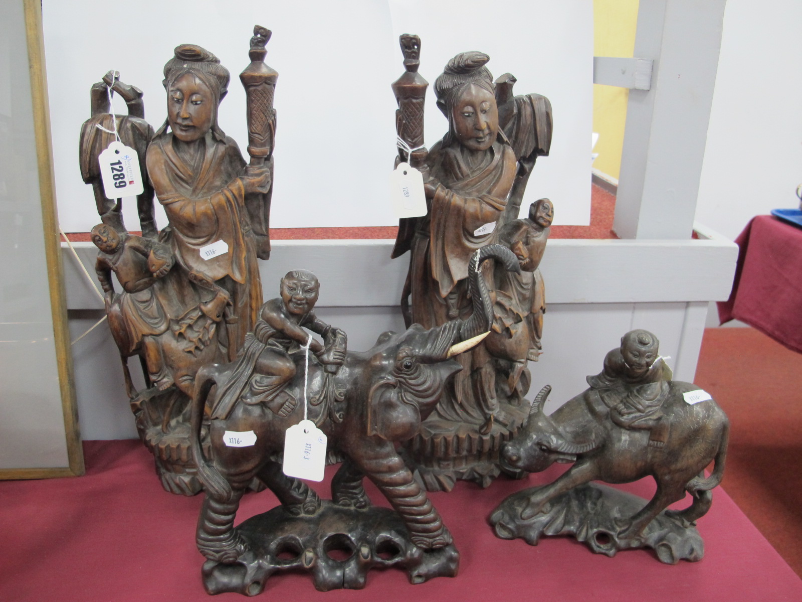 A Pair of Carved Oriental Hardwood Figures, together with two other hardwood figures of a boy on