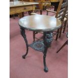 A Pub Table, with circular wooden top, 49cm diameter, on ornate black metal legs.