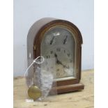 An Early XX Century Mantle Clock, the oak case with two columns to the sides, silvered dial, with