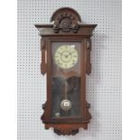 An Early XX Century Walnut Cased Wall Clock, with carved and applied decoration, white dial, with