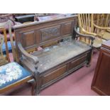 An Early XX Century Oak Hall Bench, with a panelled back, shaped arms, hinged seat, panelled base,