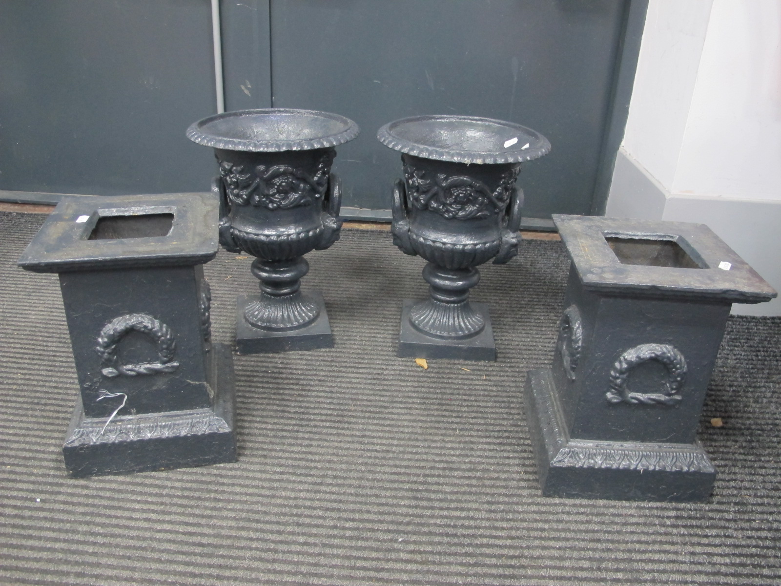 A Pair of Painted Cast Iron Garden Urns, with egg - dart decoration, twin handles, on stands 68cm