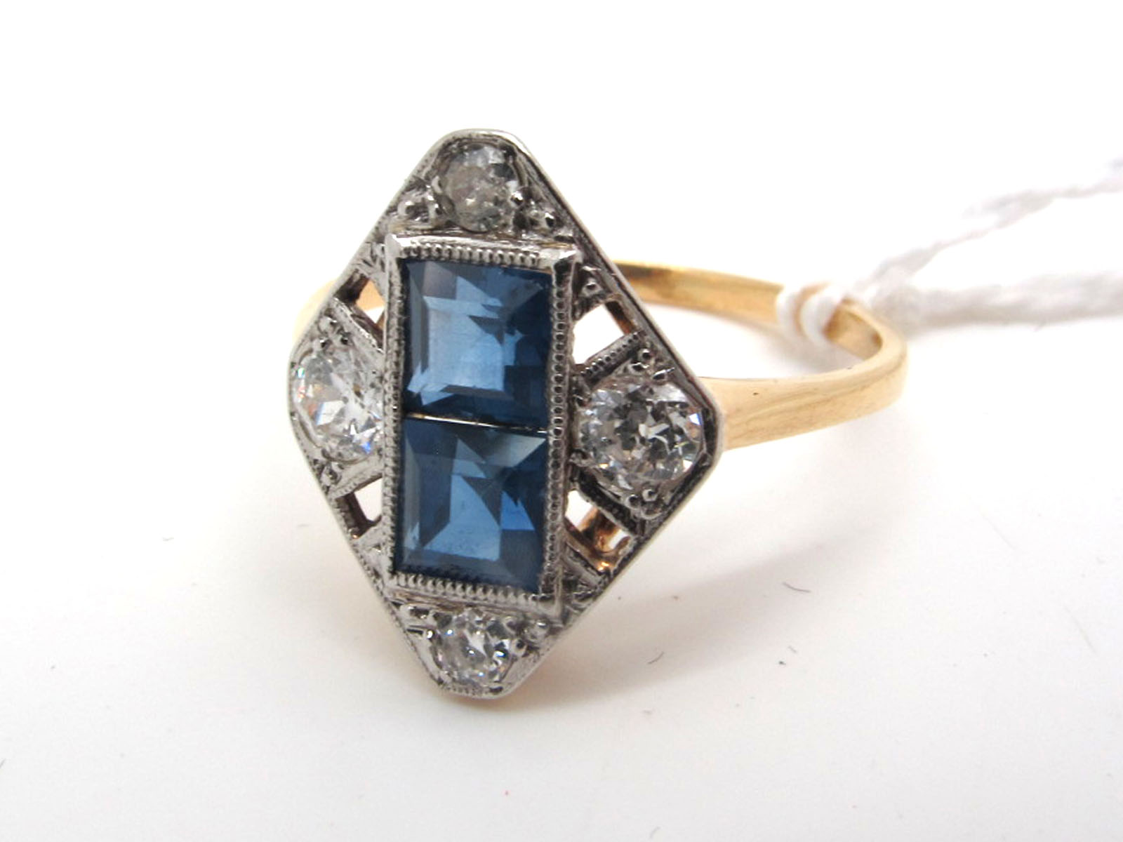 An Art Deco Sapphire and Diamond Panel Ring, rectangular collet set to the centre with two uniform