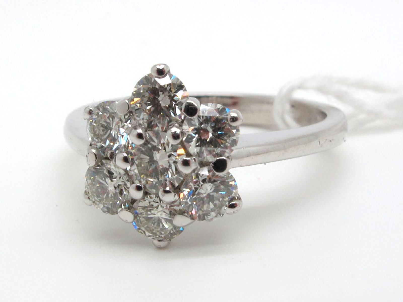 An 18ct White Gold Seven Stone Diamond Cluster Ring, of flowerhead design, claw set with brilliant