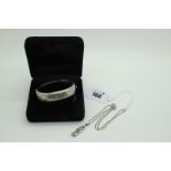 A Hallmarked Silver Hinged Bangle, leaf scroll engraved to the front, hinged to snap clasp, with