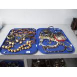 Two Trays of Ethnic Style Costume Jewellery, including large bead necklaces, wide bangles, etc.