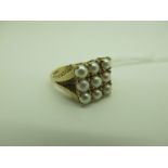 A 9ct Gold Half Pearl Set Dress Ring, claw set, between tapering textured shoulders (finger size