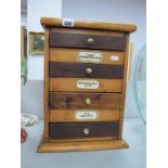 A Four Drawer Pine Table Top Cabinet with Apothecary Labels, 40cm high.