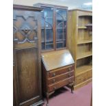 A XX Century Walnut Bureau Bookcase, the top with glazed doors, bureau with a fall front, three long