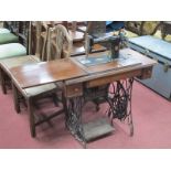 A Singer Treadle Sewing Machine, with accessories in two drawers.